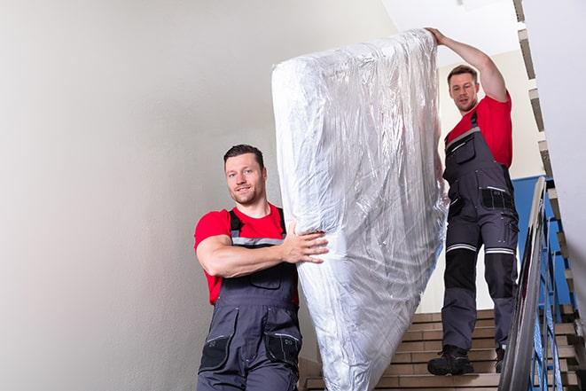 disposal crew handling a box spring during pickup in Oakham